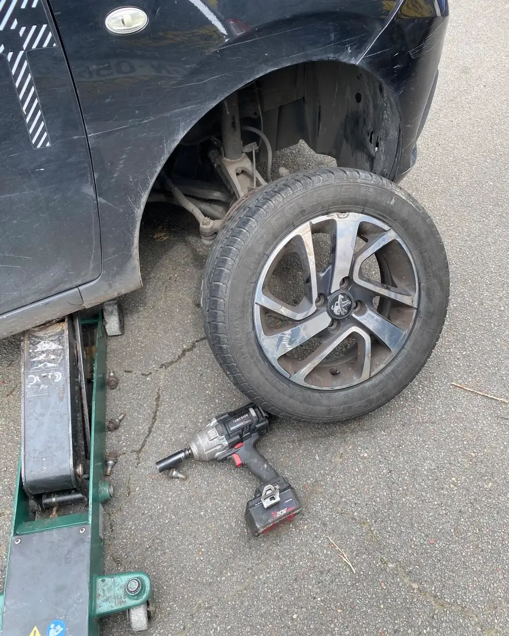 Réparation de pneu crevé sur place à Valenciennes : véhicule sur cric et changement de roue en intervention mobile.